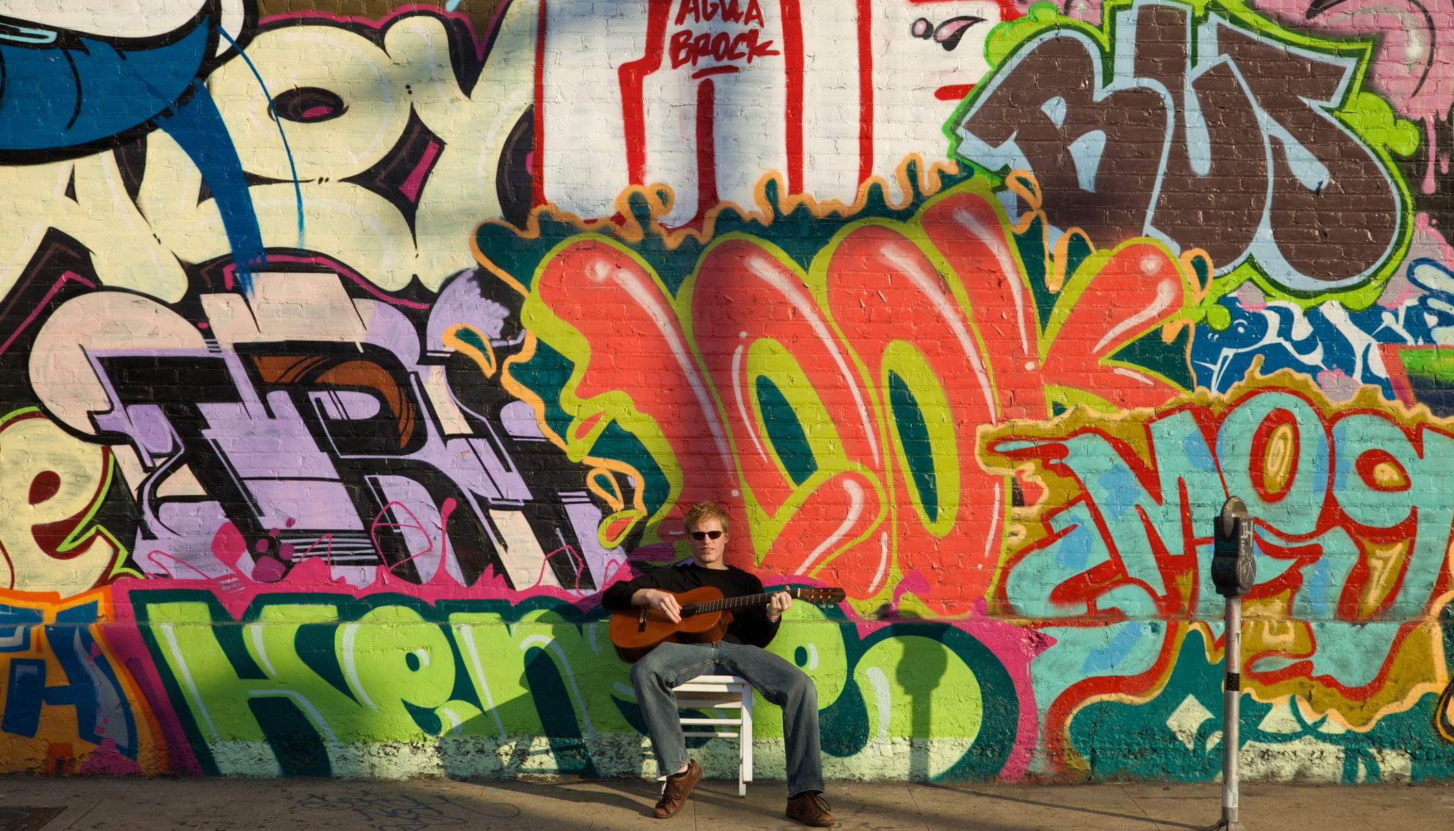 Young Musician on Street with Graffiti