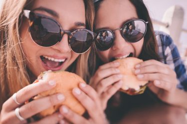Girl best friends enjoying burgers